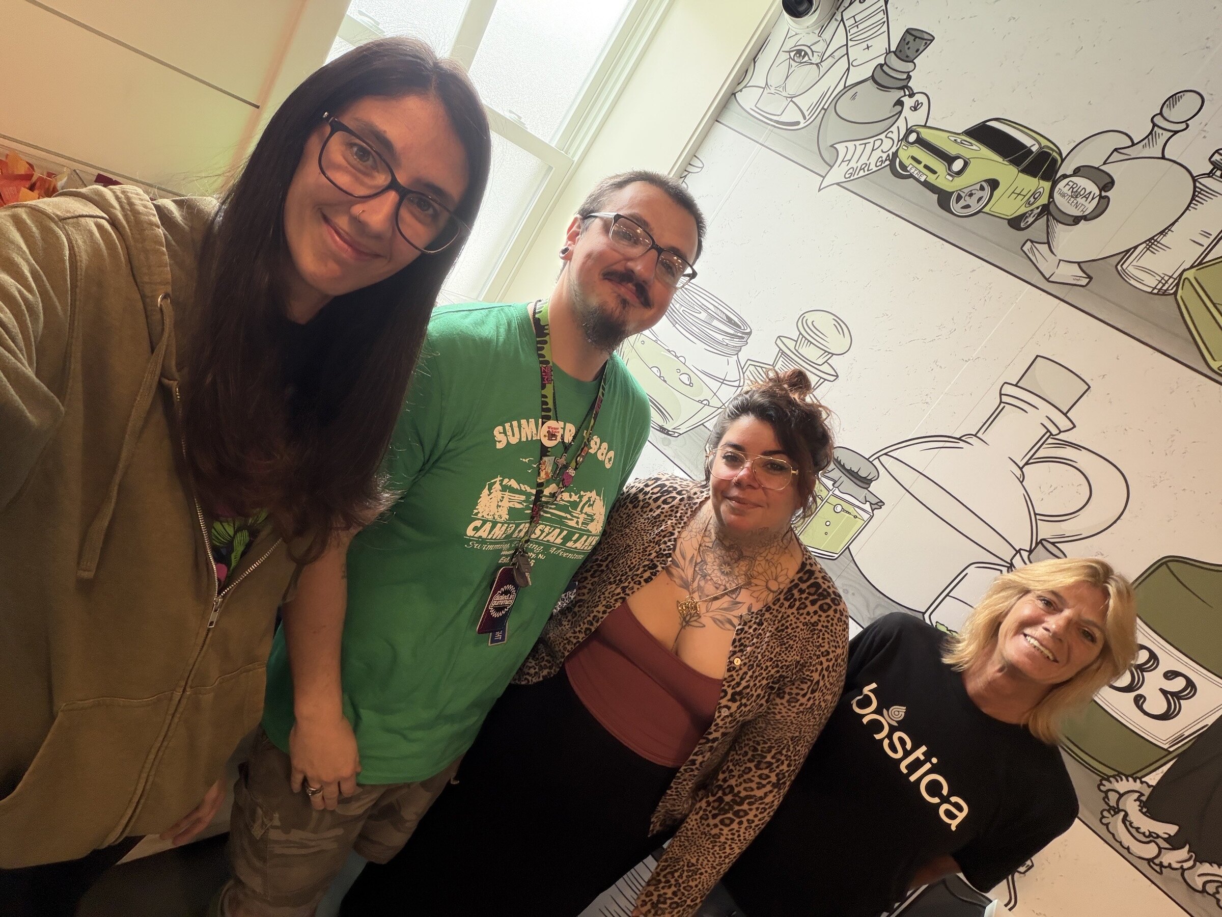 Four Essex Apothecary team members smiling together inside their Lynn dispensary