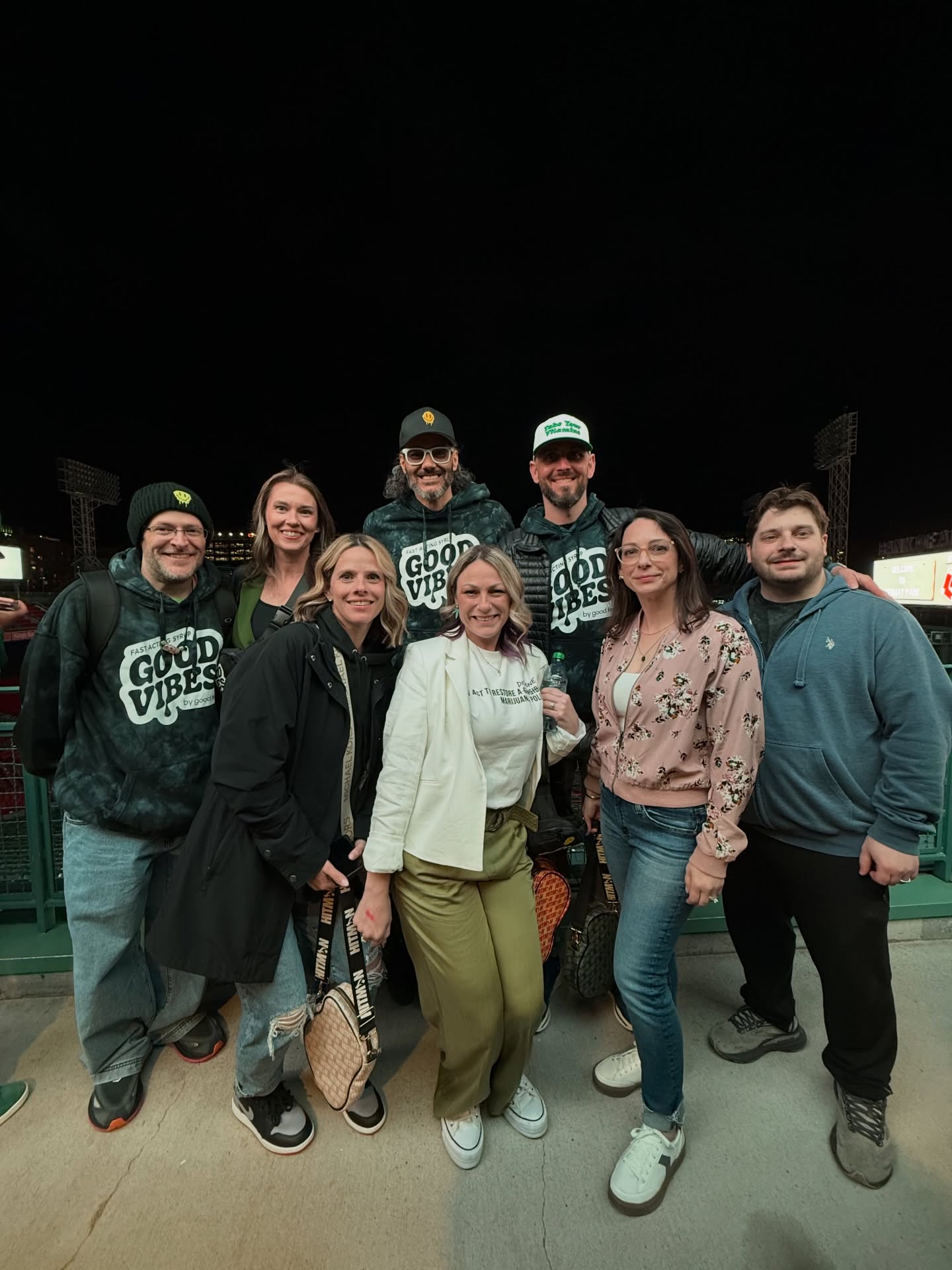 Eight people together inside Fenway Park, including three members of the Good Feels team